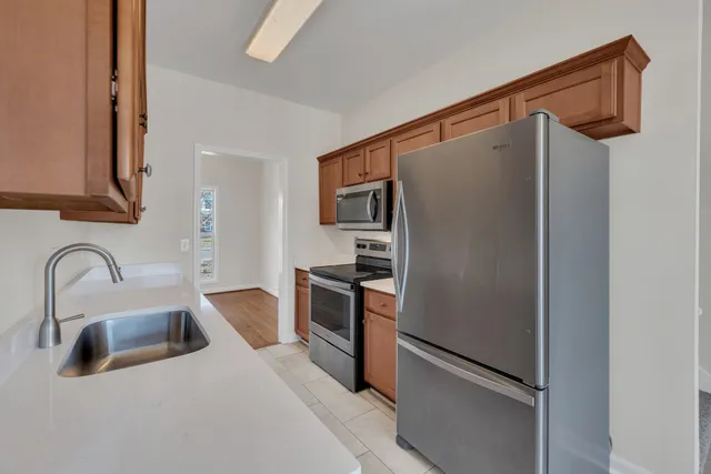 a kitchen with stainless steel appliances granite countertop a refrigerator and a sink