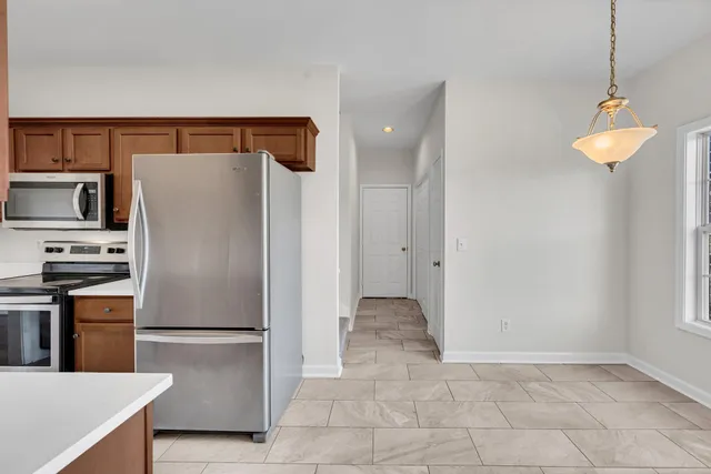 a kitchen with stainless steel appliances a refrigerator and a stove top oven
