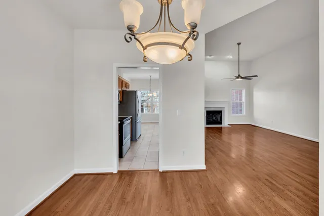 a view of empty room with wooden floor and ceiling fan