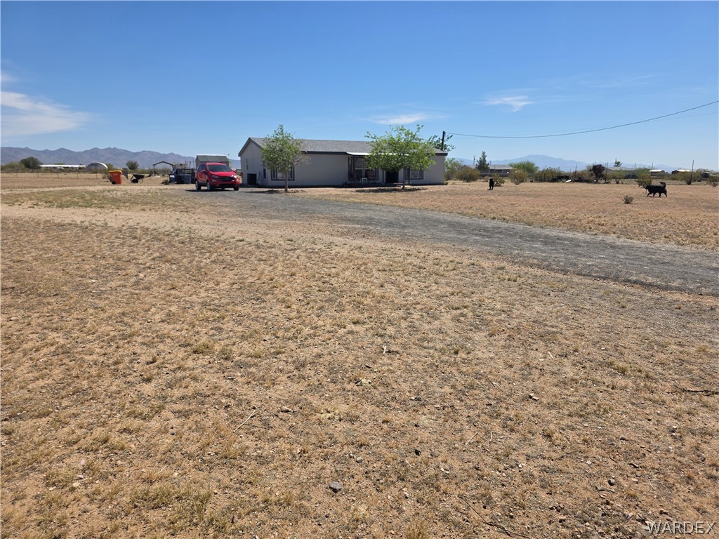 4182 Canelo Road Golden Valley, AZ 86413 - Photo 14 of 31 The property features an expansive, dry landscape with a gravel driveway leading to the house