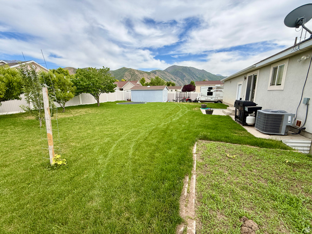 1353 360 West Payson, UT 84651 - Photo 13 of 16 Expansive backyard featuring a large lawn, white privacy fencing, and mature trees