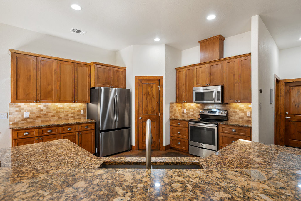 267 Corral Road Smithville, TX 78957 - Photo 21 of 40 a kitchen with stainless steel appliances granite countertop a refrigerator stove and oven