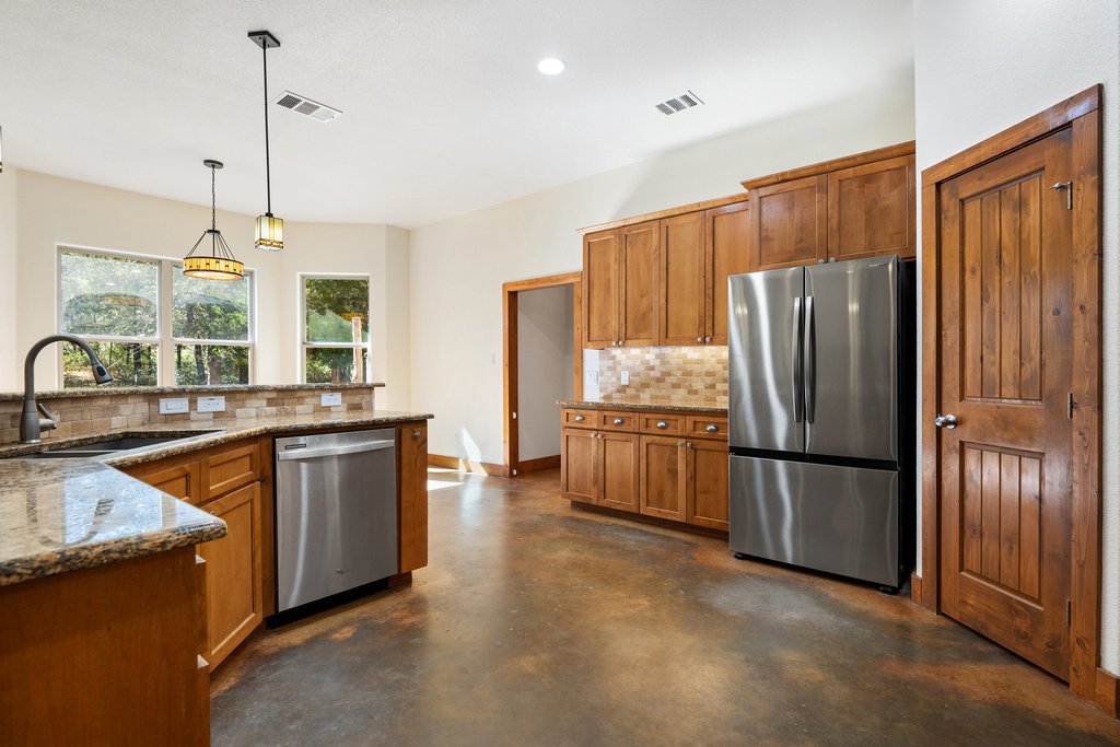 267 Corral Road Smithville, TX 78957 - Photo 22 of 40 a kitchen with stainless steel appliances granite countertop a refrigerator a sink dishwasher a stove and a sink with wooden floor