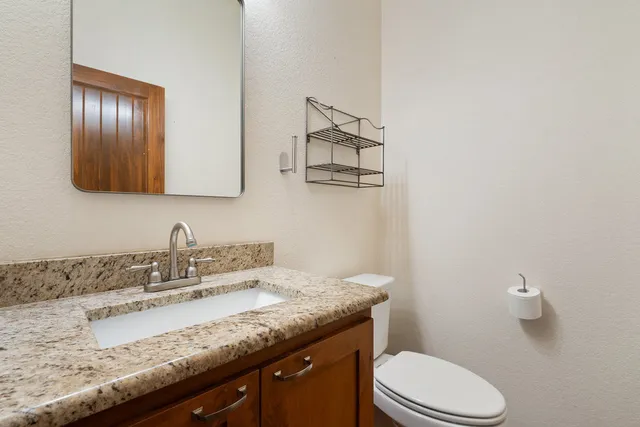 a spacious bedroom with a large bed and a chandelier fan