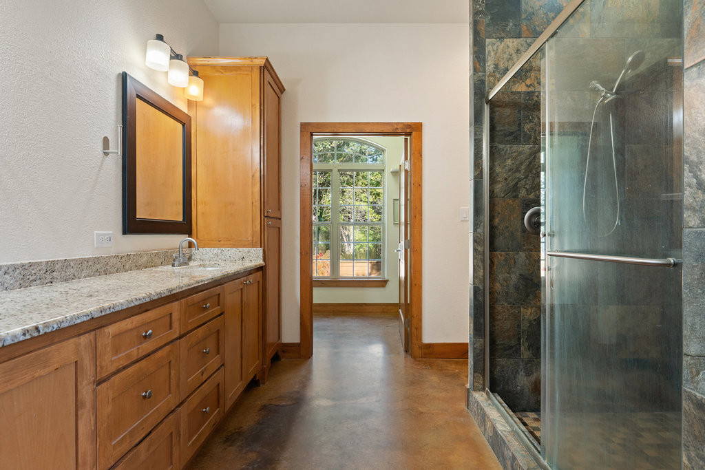 267 Corral Road Smithville, TX 78957 - Photo 28 of 40 a bathroom with a granite countertop sink mirror and a shower