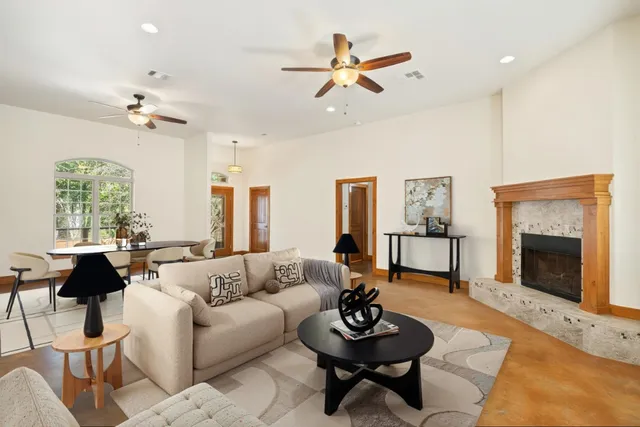 a living room with furniture a chandelier and a fireplace