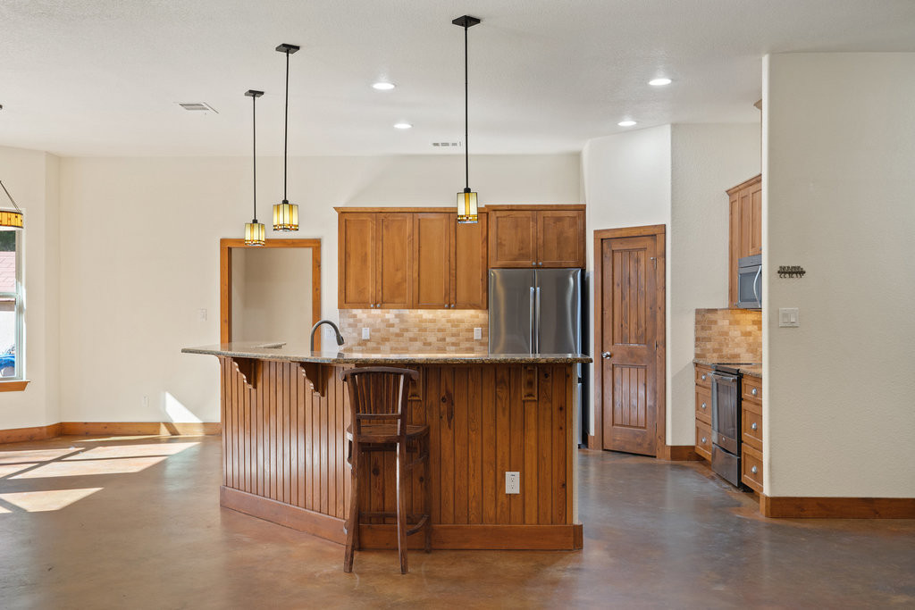 267 Corral Road Smithville, TX 78957 - Photo 4 of 40 a kitchen with stainless steel appliances granite countertop a refrigerator a sink and a stove