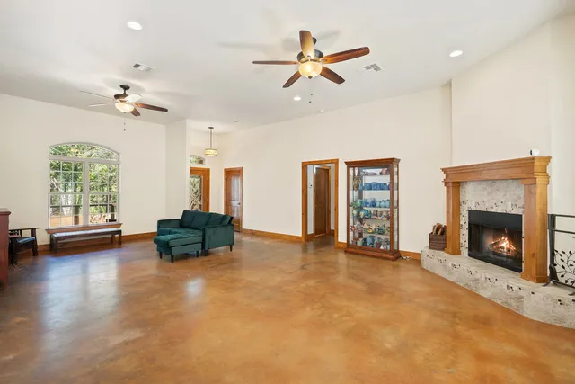 a view of an empty room with window and fire place