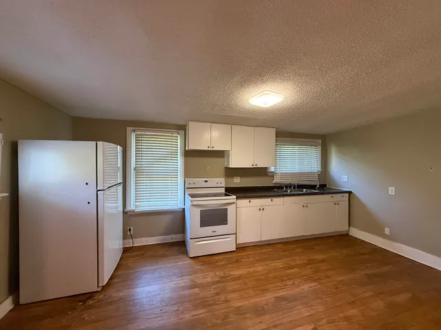 a view of a kitchen with a refrigerator and a stove top oven