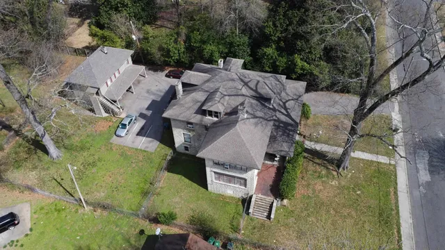 an aerial view of a house with a yard and large tree