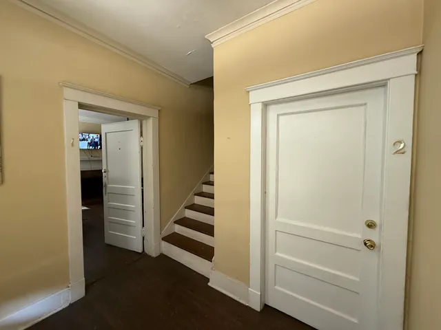a view of a hallway with wooden floor and entryway