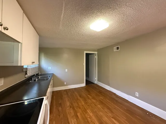 a front view of a house with a garden and parking