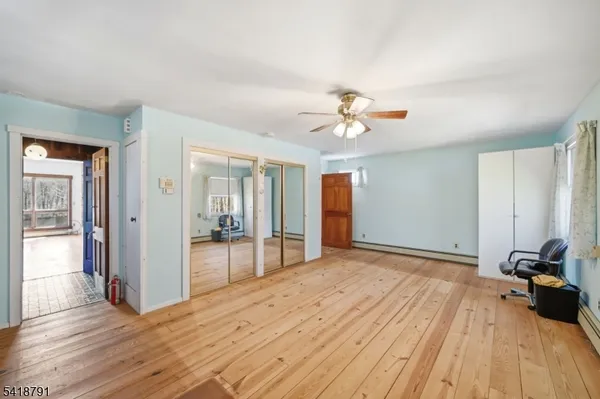 a view of a room with wooden floor and ceiling fan