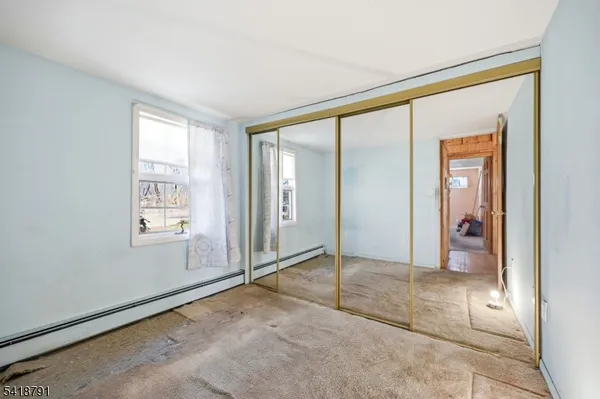 an empty room with windows and closet