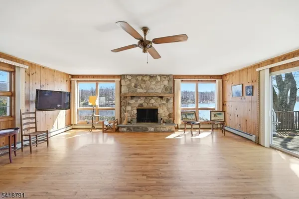 a living room with furniture floor to ceiling window and a fireplace