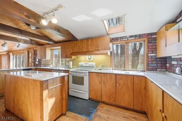 a kitchen with stainless steel appliances granite countertop a sink a stove and a wooden floors