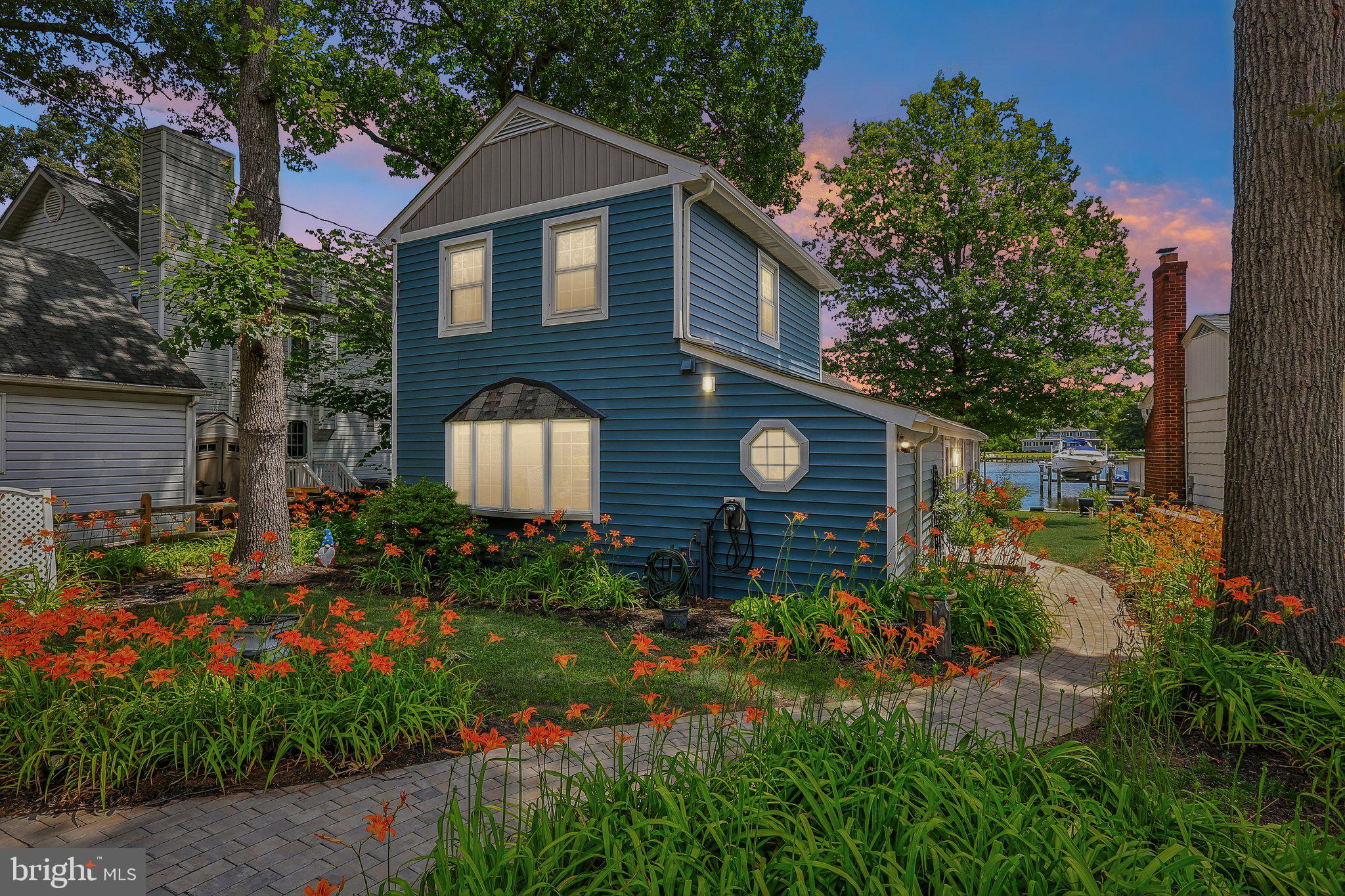 275 Gibson Road Pasadena, MD 21122 - Photo 53 of 59 Charming blue home amid vibrant blooms.