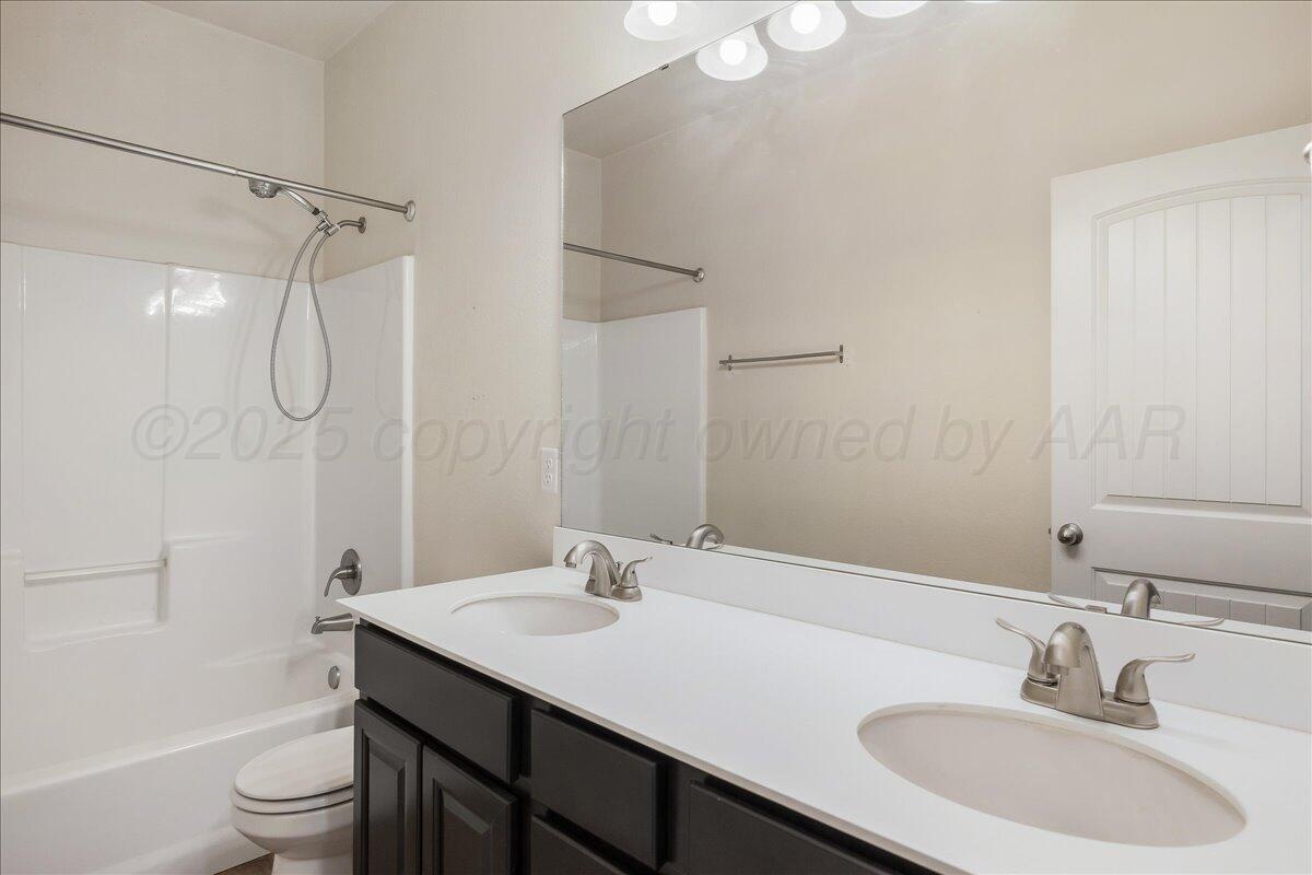 1007 Shiraz Boulevard Amarillo, TX 79124 - Photo 17 of 21 a bathroom with a sink toilet a shower and a mirror