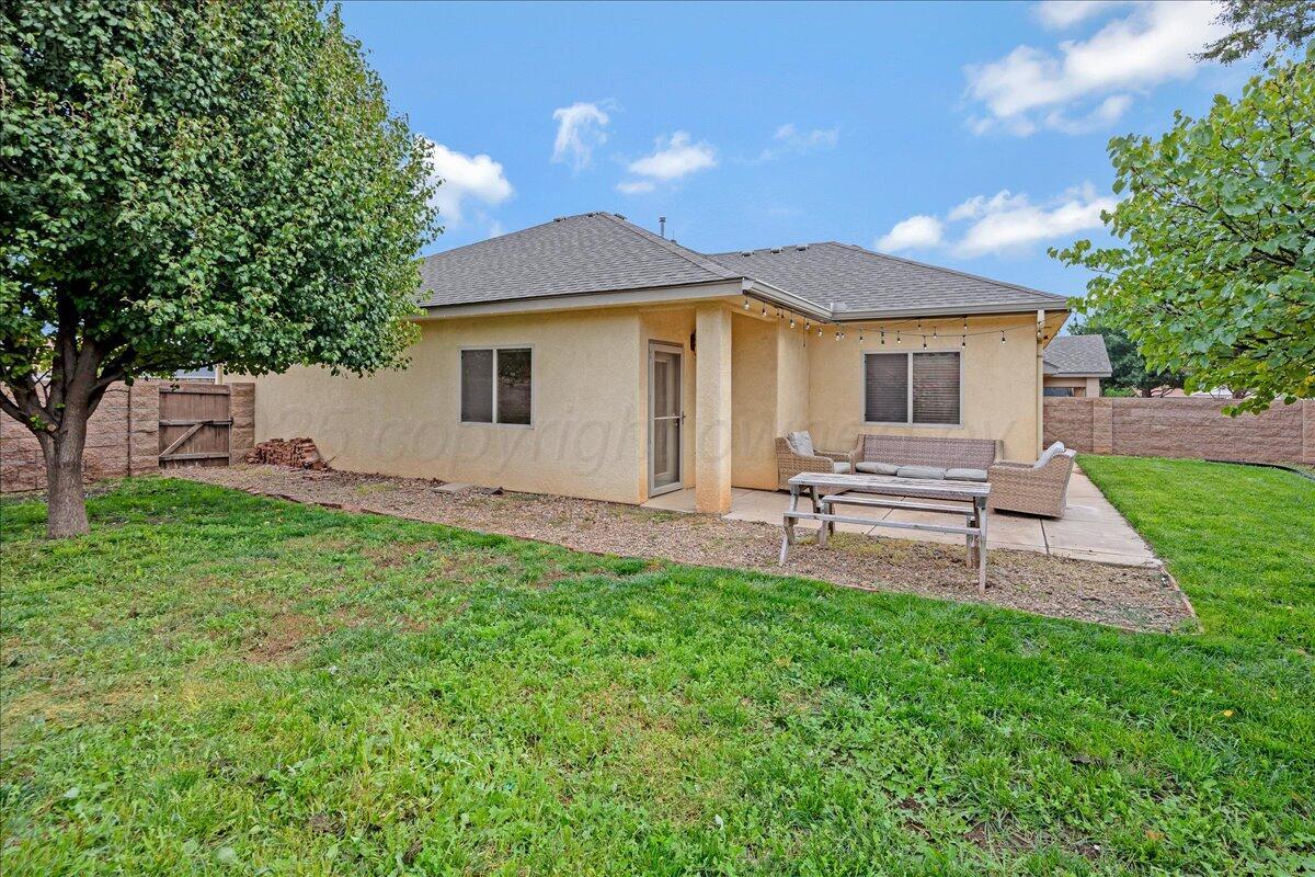 1007 Shiraz Boulevard Amarillo, TX 79124 - Photo 19 of 21 a white house with a small yard and big trees with wooden fence