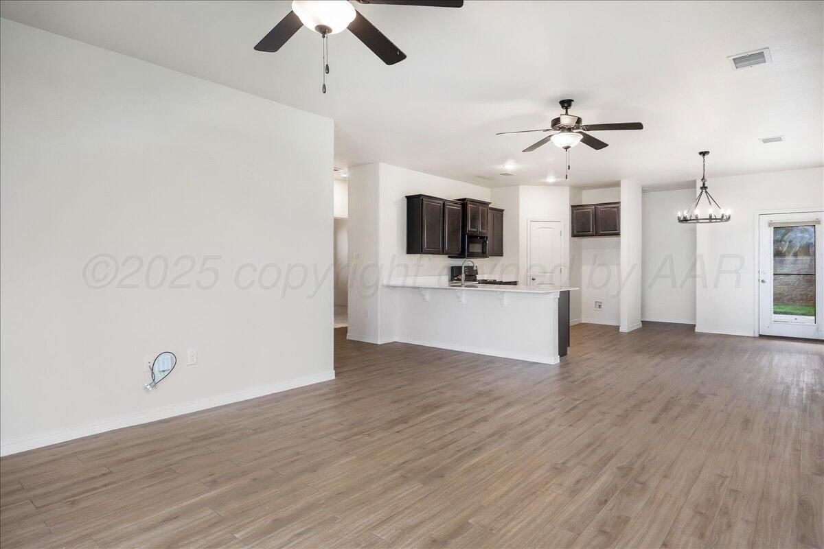 1007 Shiraz Boulevard Amarillo, TX 79124 - Photo 5 of 21 a view of a livingroom with a flat screen tv wooden floor and a ceiling fan