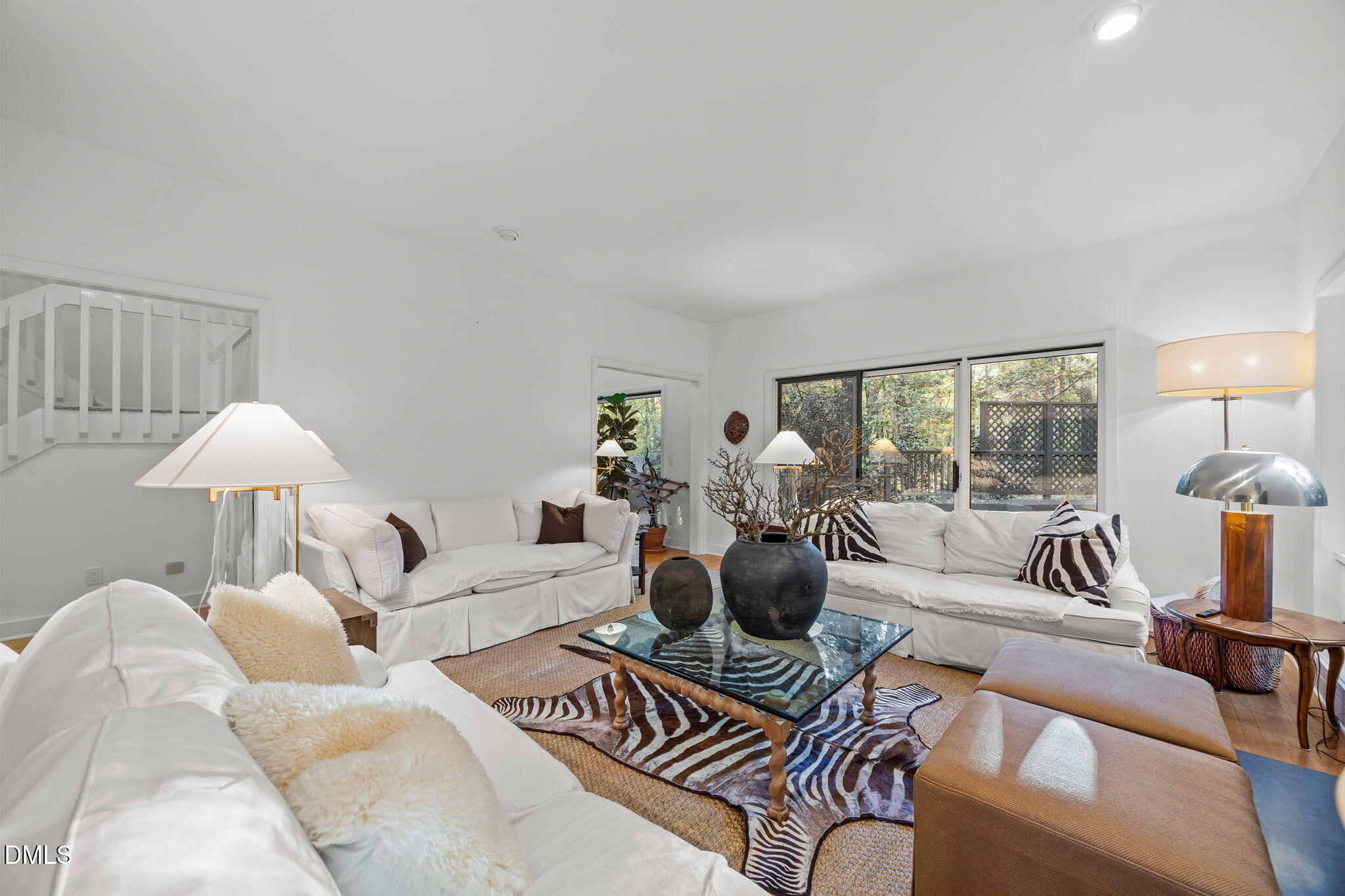 a living room with furniture a lamp and a large window