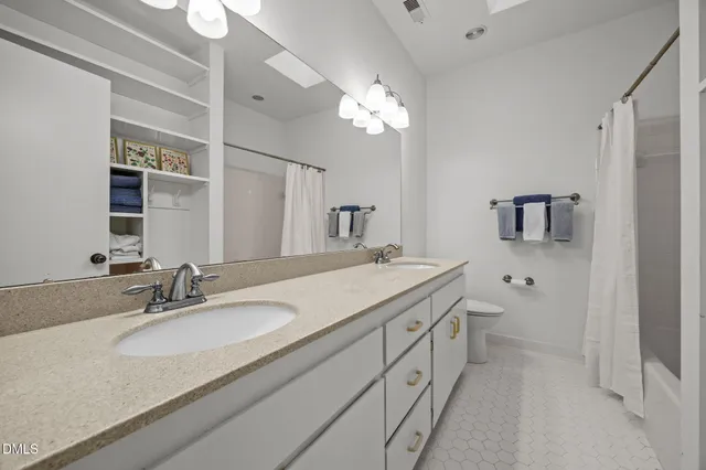 a bathroom with a granite countertop sink a large mirror and a bathtub