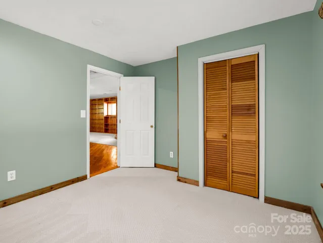 an empty room with closet and windows