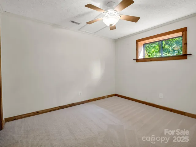 an empty room with a window and a ceiling fan