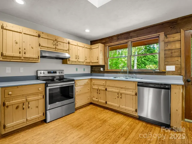 a kitchen with stainless steel appliances granite countertop a stove a sink and a microwave