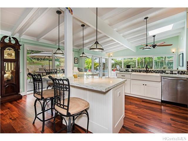 a kitchen with stainless steel appliances kitchen island granite countertop a table chairs sink and wooden floor