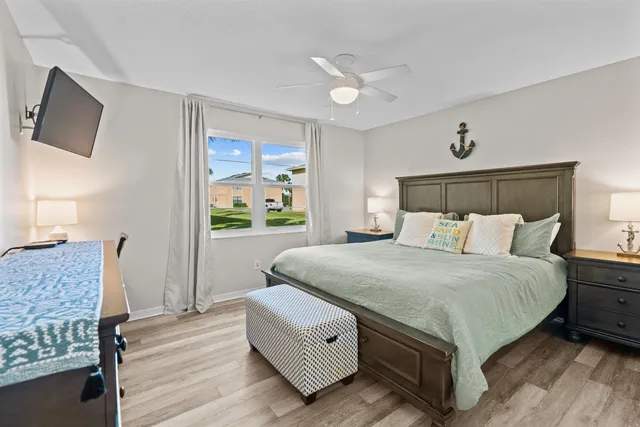 a bedroom with a bed and a flat tv screen on dresser