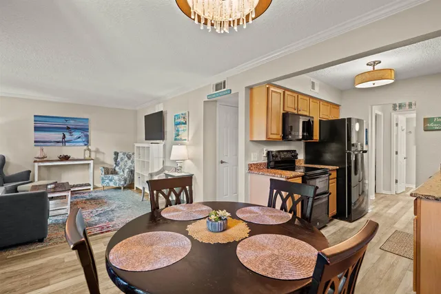a view of a dining room with furniture a chandelier and wooden floor