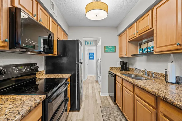 a kitchen with granite countertop lots of counter top space and wooden floor