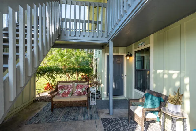 a view of a porch with furniture and a yard