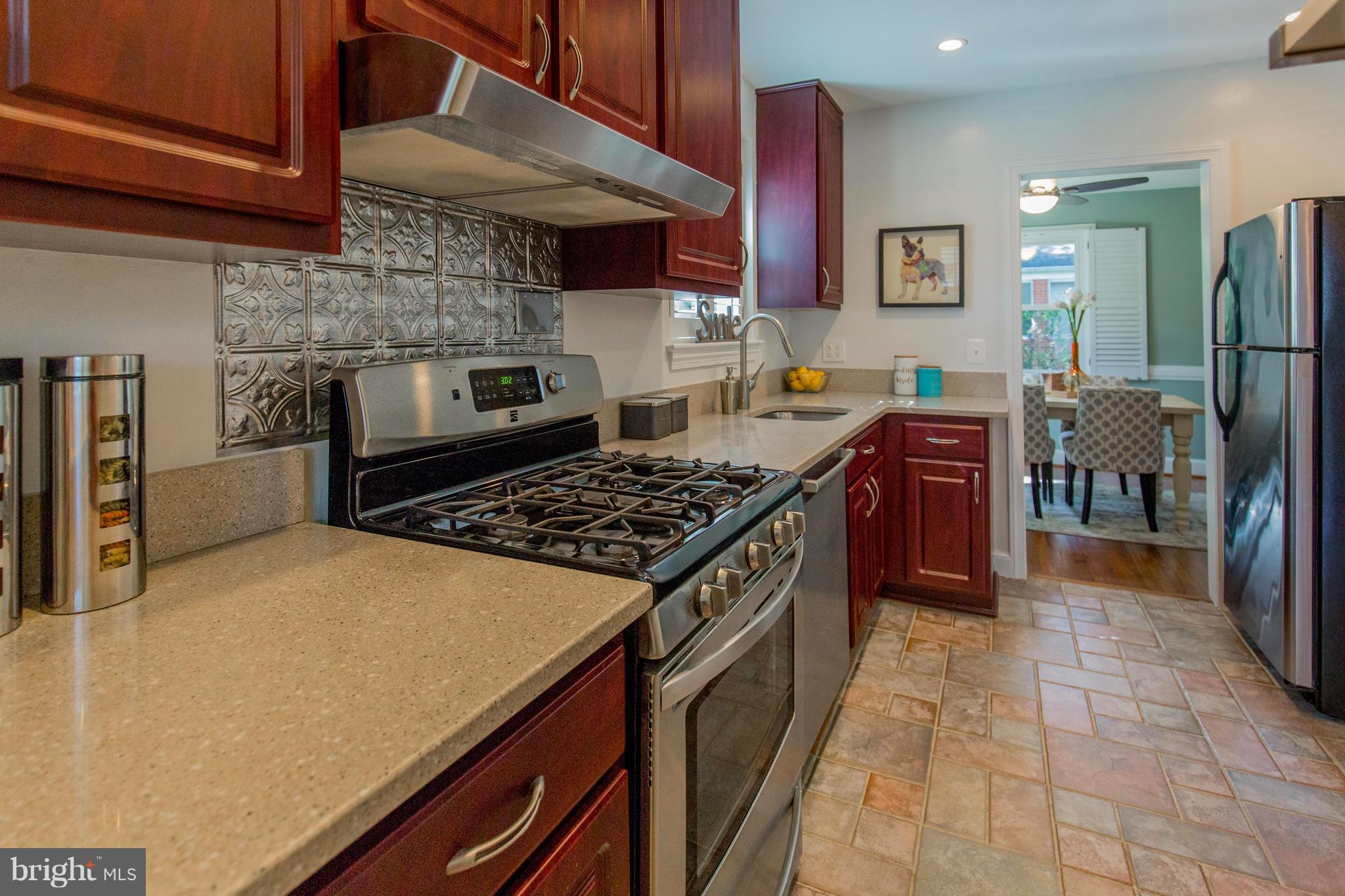 9010 Eton Road Silver Spring, MD 20901 - Photo 14 of 30 a kitchen with stainless steel appliances granite countertop a stove top oven a sink dishwasher and a refrigerator