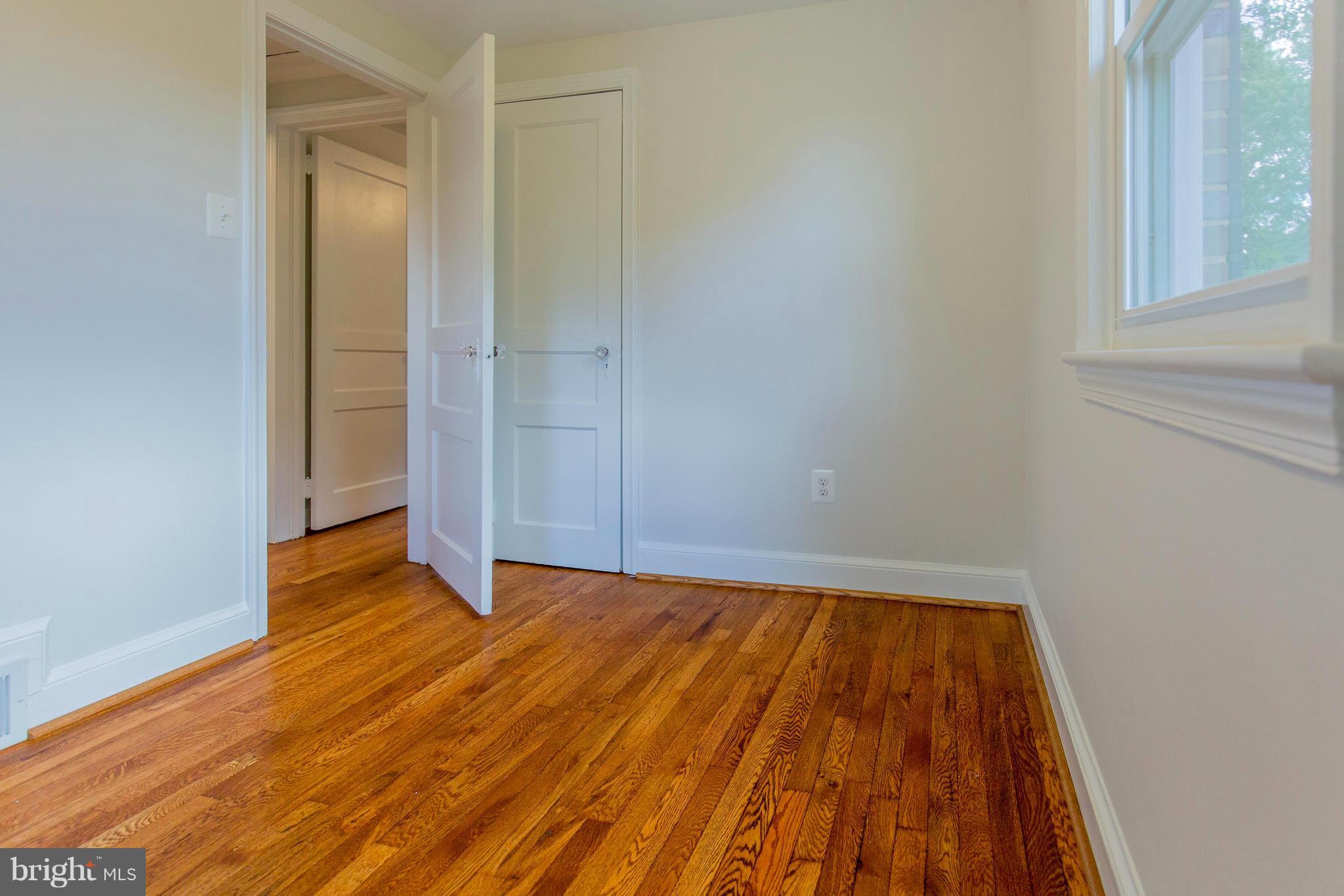 9010 Eton Road Silver Spring, MD 20901 - Photo 22 of 30 a view of an empty room with wooden floor and a window