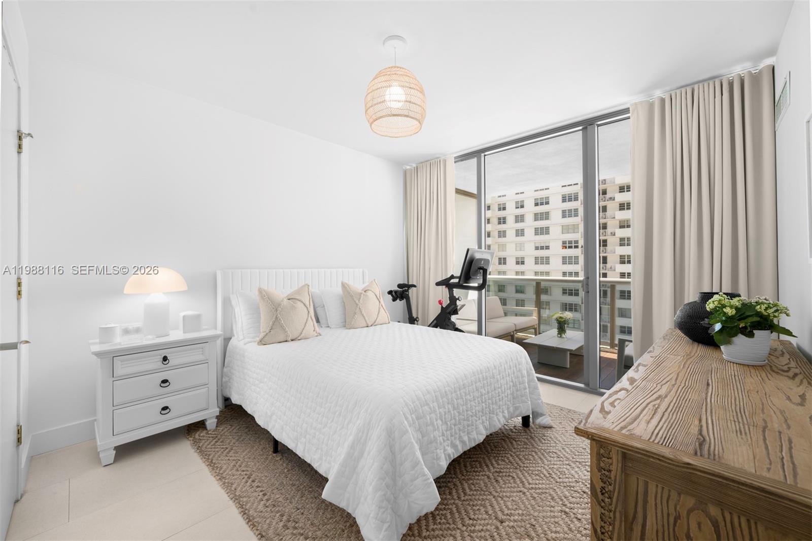 5875 Collins Avenue, Unit 906 Miami Beach, FL 33140 - Photo 14 of 20 a bedroom with a large bed and a chandelier