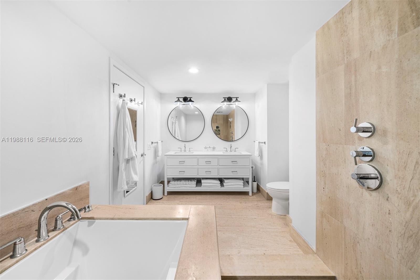 5875 Collins Avenue, Unit 906 Miami Beach, FL 33140 - Photo 17 of 20 a bathroom with a tub sink and mirror