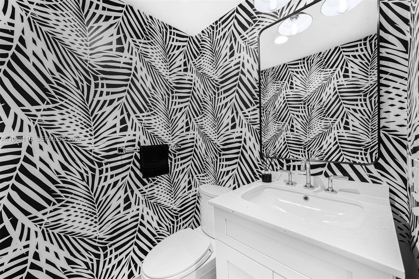 5875 Collins Avenue, Unit 906 Miami Beach, FL 33140 - Photo 19 of 20 a bathroom with a sink a toilet and mirror