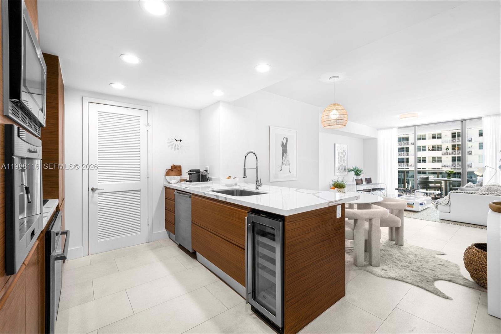 5875 Collins Avenue, Unit 906 Miami Beach, FL 33140 - Photo 4 of 20 a kitchen with a sink stove and cabinets
