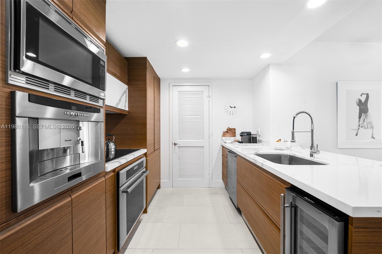 5875 Collins Avenue, Unit 906 Miami Beach, FL 33140 - Photo 5 of 20 a kitchen with stainless steel appliances granite countertop a sink and a stove