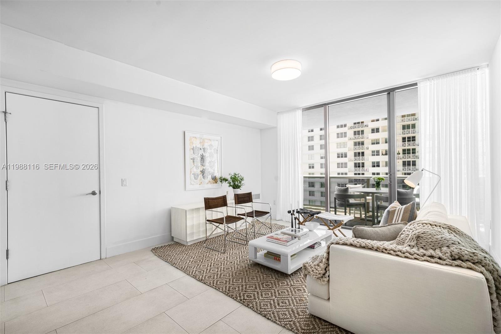 5875 Collins Avenue, Unit 906 Miami Beach, FL 33140 - Photo 10 of 20 a living room with furniture and a large window
