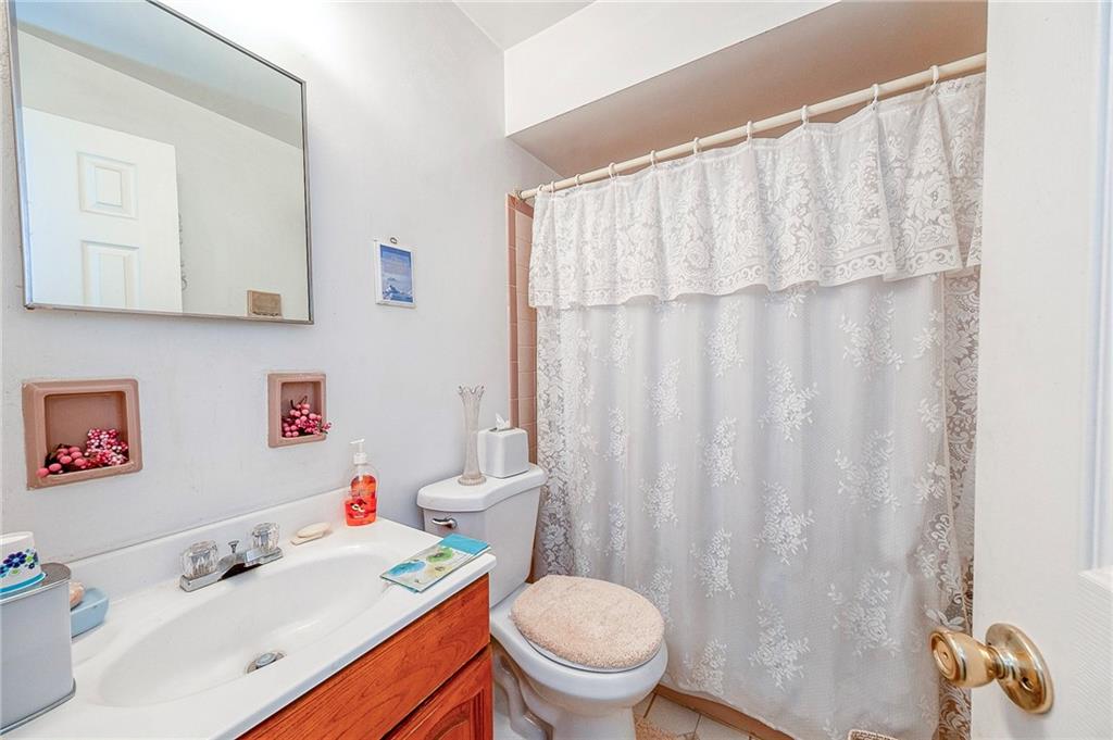 923 Locust Street Coraopolis, PA 15108 - Photo 14 of 27 a bathroom with a sink a toilet and a shower curtain