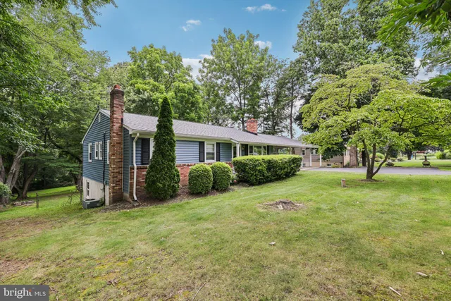 a view of a house with a yard and tree s