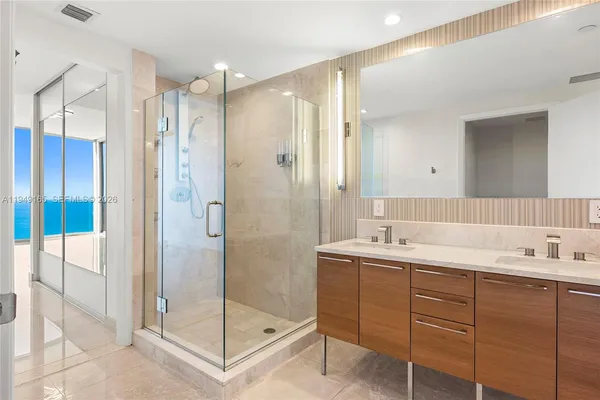 a bathroom with a shower sink and mirror