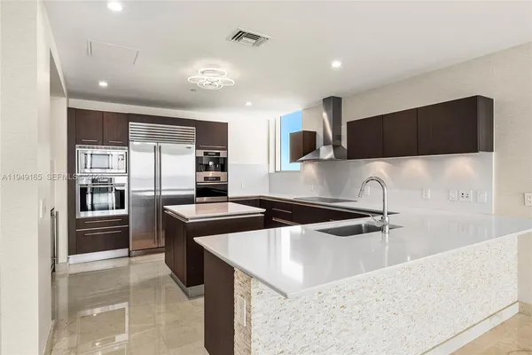 a kitchen with stainless steel appliances granite countertop a sink a stove and a refrigerator