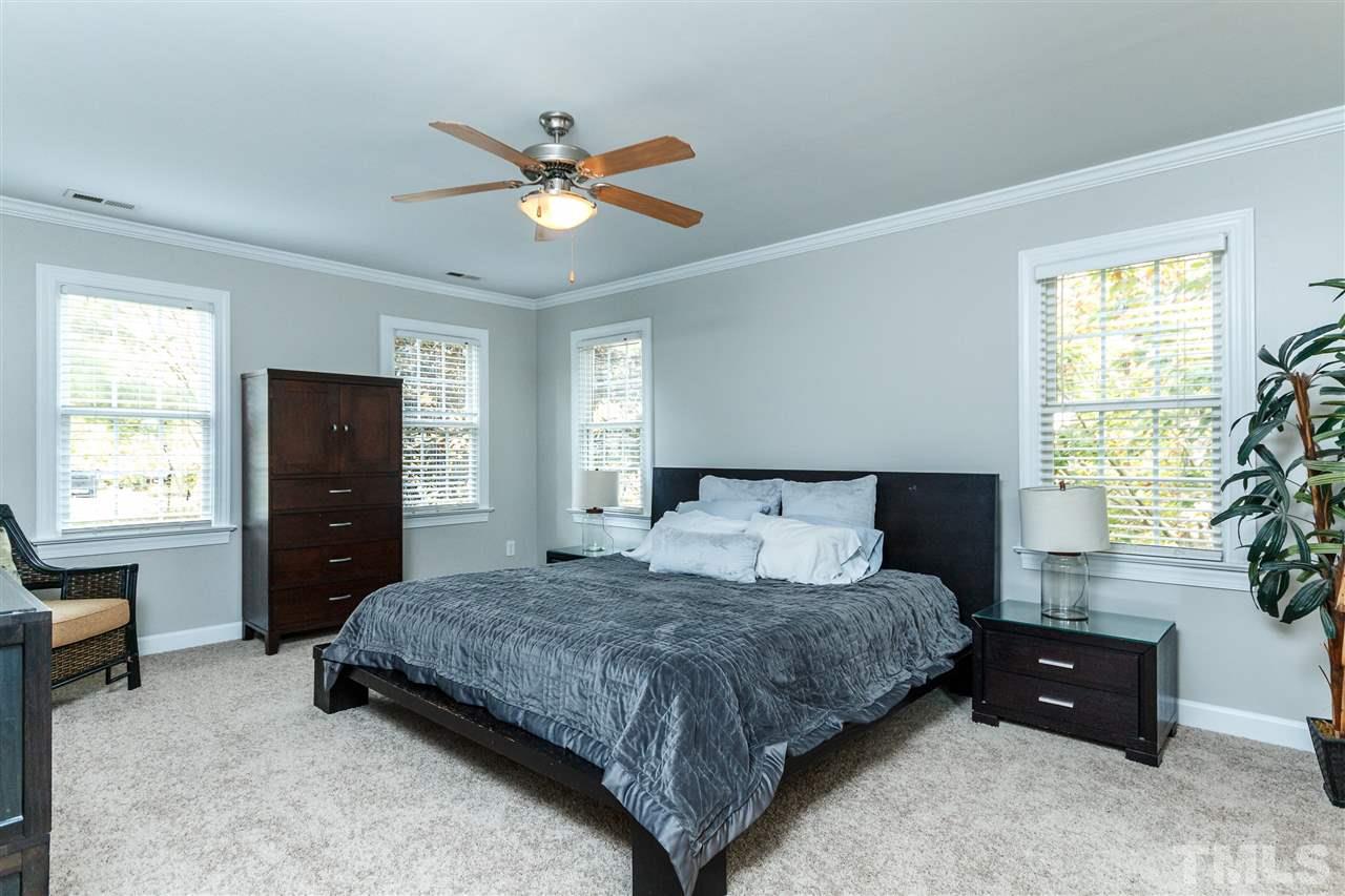 2936 Sunnystone Way Raleigh, NC 27613 - Photo 13 of 29 a bedroom with a bed and a chandelier