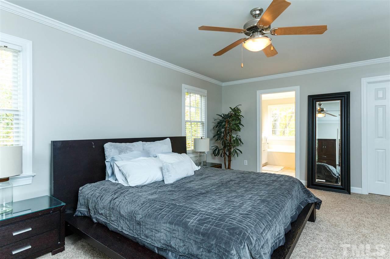 2936 Sunnystone Way Raleigh, NC 27613 - Photo 14 of 29 a spacious bedroom with a large bed and a chandelier