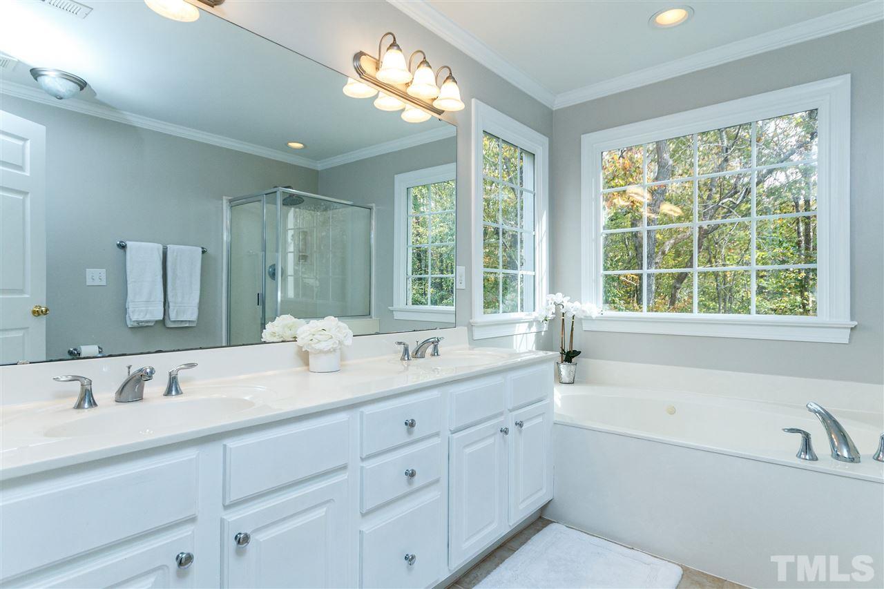 2936 Sunnystone Way Raleigh, NC 27613 - Photo 15 of 29 a bathroom with a tub a sink double vanity and a window