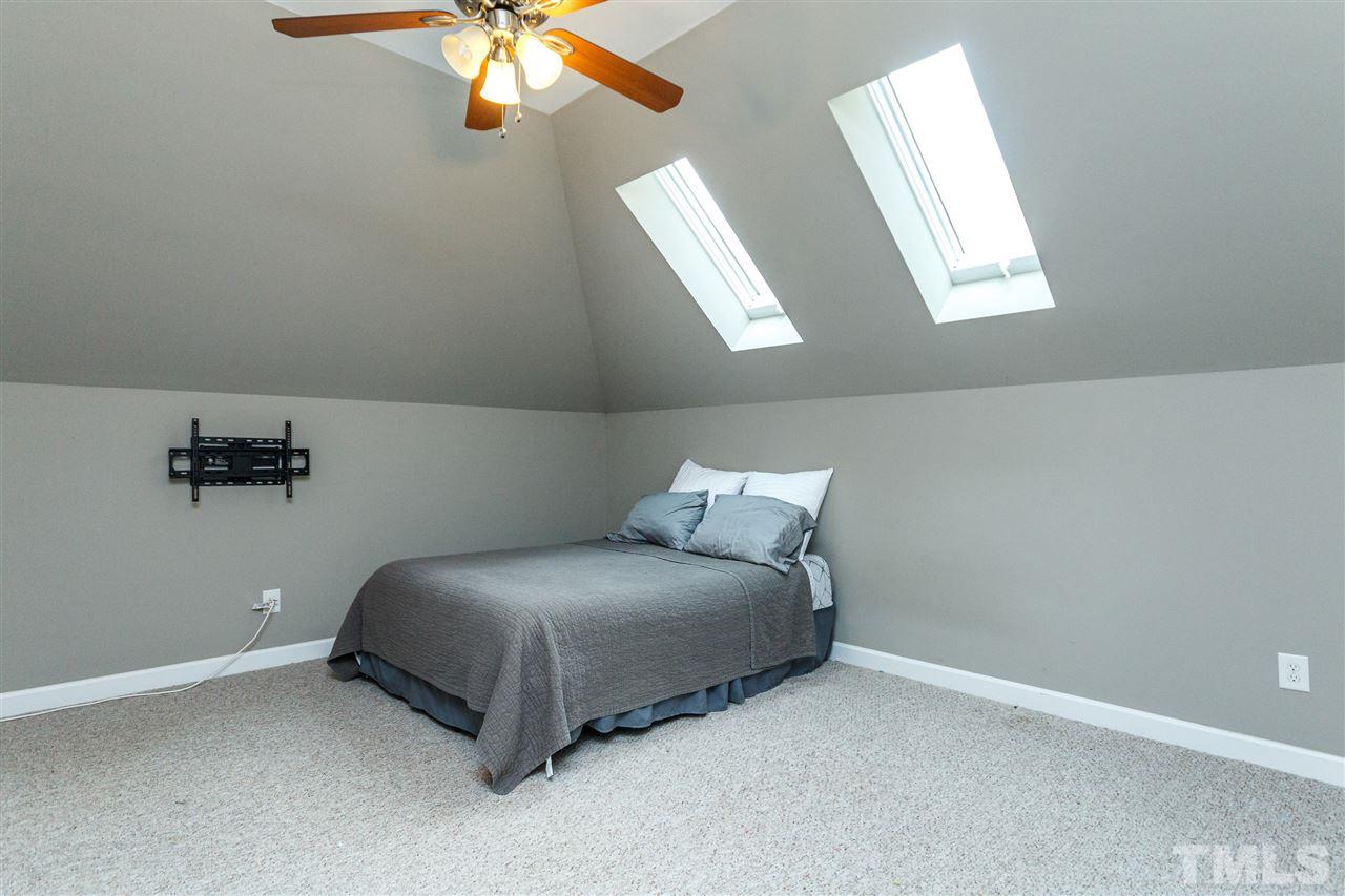 2936 Sunnystone Way Raleigh, NC 27613 - Photo 21 of 29 a bed room with a bed and a chandelier